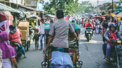 selective photography of man pedaling wagon